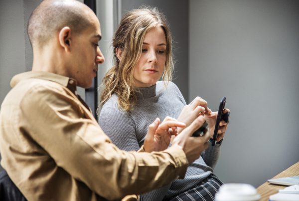 Man showing something on a smartphone to a woman