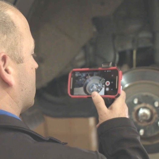 a man takes a video of his car repair.