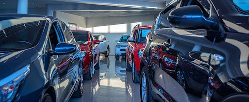 Six new cars in a showroom at a car dealership